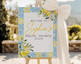 May include: A welcome sign for a bridal shower, featuring a white background with a blue and yellow tile border. The sign includes the text "Welcome to Sophia's Bridal Shower" and the date 05.05.2026. The sign is decorated with lemon and floral illustrations.