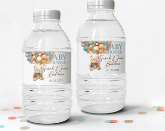 May include: Two clear plastic water bottles with personalized labels for a baby shower. The labels feature a teddy bear holding blue and beige balloons, with the text "BABY SHOWER Sarah & James Baldwin 01.25.2023".