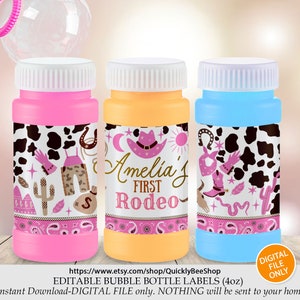 May include: Three pink, orange, and blue bubble bottles with labels featuring a cow print background, pink bandana, cowboy hat, and the text "Amelia's First Rodeo".