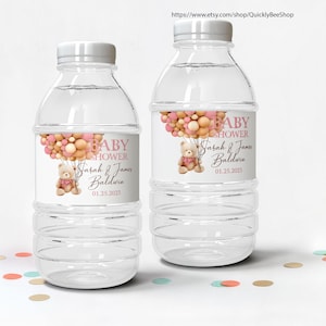 May include: Two clear plastic water bottles with white caps. Each bottle has a label with the text "BABY SHOWER" above the names "Sarah & James Baldwin" and the date "01.25.2023". The labels feature a teddy bear and balloons.