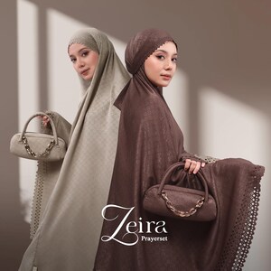 May include: Two women wearing matching prayer sets in beige and brown. Each set includes a head covering and a matching handbag with a chain strap. The sets have a delicate lace trim. The brand name "Zeira Prayerset" is displayed in elegant script.
