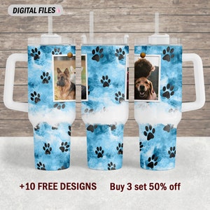 May include: Three stainless steel tumblers with a blue and white paw print design. Each tumbler has a white lid and a straw. The tumblers are on a wooden background.  +10 FREE DESIGNS Buy 3 set 50% off