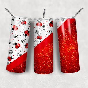 May include: Three cylindrical tumblers with metal straws, featuring a white background with red ladybug and black flower patterns, transitioning into a diagonal section of vibrant red glitter texture at the bottom of each vessel.