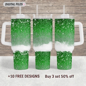 May include: Three green glitter tumbler cups with white lids and handles. The tumblers have a white layer in the middle, creating a layered effect. The text "Buy 3 set 50% off" and "+10 FREE DESIGNS" is at the bottom of the image.