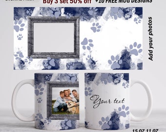 May include: Two white ceramic mugs with a blue and white paw print design. One mug has a photo frame with a family photo of a dog and three people. The other mug has the text "Your text" in black cursive writing. The mugs are 15 oz and 11 oz.