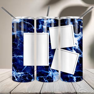 May include: Three cylindrical tumblers with a dark blue and white marble pattern. Each tumbler features a metallic straw and white rectangular frames for photo placement. The design includes one vertical rectangle on the left and two tilted square frames on the right, set against a deep blue marbled background.