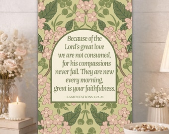 May include: A framed canvas print with a floral design in shades of green and pink. The print features the text "Because of the Lord's great love...great is your faithfulness." from Lamentations 3:22-23. The print is displayed on a wooden surface.