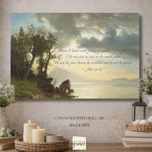 May include: Canvas wrapped wall art featuring a landscape painting with a lake, trees, and a cloudy sky. The artwork includes a quote from John 14:27. The dimensions are 36x24 inches.