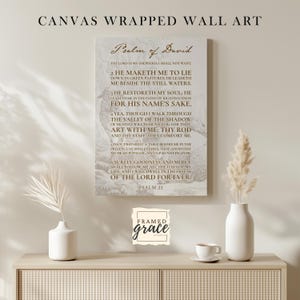 Puede incluir: Un lienzo rectangular para pared que presenta el texto del Salmo 23 en una fuente serif de color marr&oacute;n oscuro sobre un fondo beige claro. El dise&ntilde;o incluye una ilustraci&oacute;n monocrom&aacute;tica tenue de una oveja de fondo.