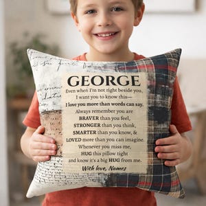 May include: A decorative pillow with a personalized message. The pillow features the name "GEORGE" at the top, with a heartfelt message below. The pillow has a plaid pattern on the right side and a vintage script design on the left.