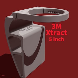 May include: A gray 3M Xtract 5 inch cup holder. The holder is made of plastic and has a textured surface. It is designed to hold a cup or bottle.