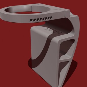 May include: A gray 3D printed phone holder with a circular top and a textured design. The holder has a curved base and a series of slots on the side.