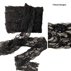 May include: Black lace trim with sequins. The trim is about 1.5 inches wide and has a scalloped edge. The trim is shown in a close-up and a full view.
