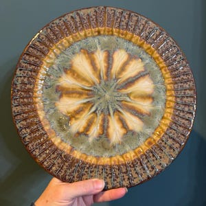 May include: A handmade, wooden serving tray with a natural finish. The tray features a rectangular shape with raised edges and integrated handles. The wood grain is visible, showcasing the tray's rustic charm. Dimensions: 18 inches long, 12 inches wide, and 2 inches high.