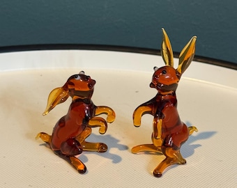 Par de figuritas de conejos en miniatura de cristal color ámbar y marrón, de estilo vintage.