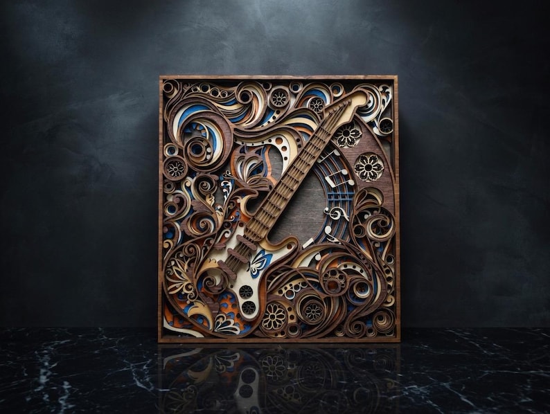 May include: A layered wooden art piece featuring an electric guitar design. The artwork incorporates intricate cut patterns, swirls, and floral motifs in shades of brown, blue, and white. The guitar is centered within a square frame.
