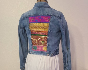 Upcycled/Recycled denim jean jacket with bohemain Indian ribbon fabric on back.  Brand Levi's.  Size is Woman's XS.