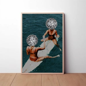 Puede incluir: Dos mujeres en una tabla de surf en el océano, cada una con una bola de discoteca sobre la cabeza. El agua es de un color azul verdoso profundo y la tabla de surf es blanca con un acabado brillante.