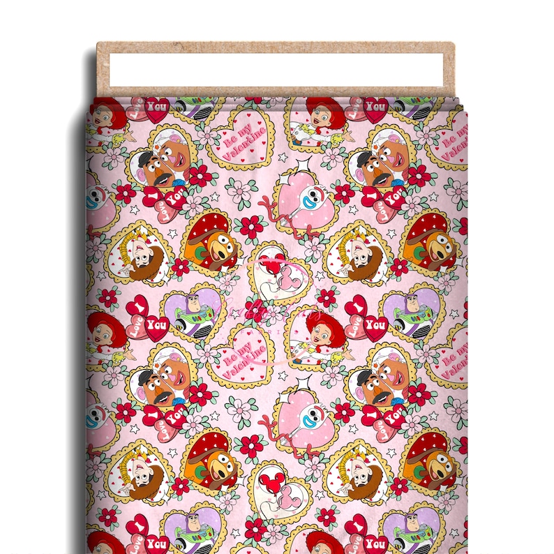 May include: Pink fabric featuring a repeating pattern of cartoon characters, hearts, and floral elements. The design includes characters like Woody, Buzz Lightyear, and others, set within heart-shaped frames. The words "Be my Valentine" and "You" are also visible.
