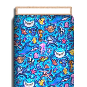 May include: A vibrant blue fabric featuring an underwater scene with cartoon sharks, fish, seahorses, and jellyfish. The design includes various sea creatures in bright colors, creating a playful and whimsical pattern. The fabric is likely for crafting or home decor.