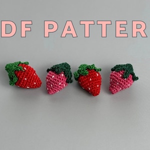 May include: Four crocheted strawberry ornaments with green tops and red or pink bodies. The text "PDF PATTERN" is displayed in pink above the strawberries. The strawberries are arranged in a row against a gray background.