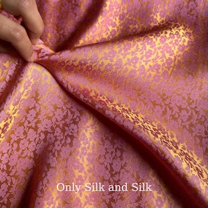 May include: A close-up of pink and gold floral silk fabric. The fabric features a repeating pattern of small flowers. The text "Only Silk and Silk" is visible at the bottom of the image.
