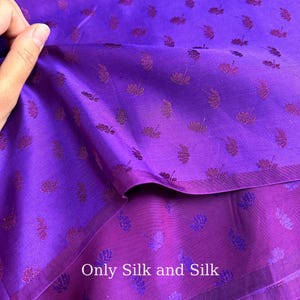 Peut inclure: Gros plan sur un tissu de soie violet avec un motif floral. Le tissu présente un effet de dégradé, passant d'un violet plus clair à une teinte plus foncée. Le texte "Only Silk and Silk" est visible en bas.