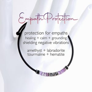 May include: A black cord bracelet featuring a series of small, square-shaped amethyst, labradorite, tourmaline, and hematite beads. The text on the image reads: Empath Protection, protection for empaths, healing + calm + grounding, shielding negative vibrations, amethyst + labradorite, tourmaline + hematite.