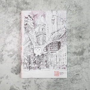 Pode incluir: Ilustração a preto e branco de uma coruja-das-neves em voo sobre uma rua da cidade. As asas da coruja estão abertas e os edifícios são detalhados. Flocos de neve caem do céu e a imagem tem um aspeto vintage.