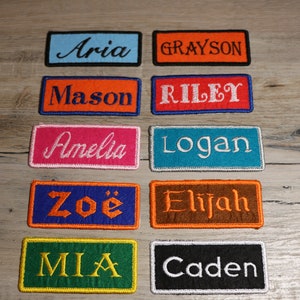 May include: Ten colourful embroidered patches with names including Aria, Grayson, Mason, Riley, Amelia, Logan, Zoé, Elijah, Mia, and Caden.