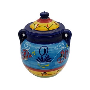 May include: A blue and yellow ceramic jar with a lid. The jar features a blue and white floral design and a yellow and red stripe around the bottom. The lid has a yellow and red floral design.