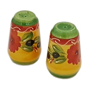 May include: A set of two ceramic salt and pepper shakers with a yellow background, green and red floral designs, and black olives.