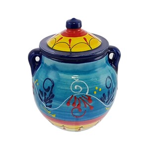 May include: A blue and yellow ceramic jar with a lid. The jar features a floral design with red and yellow accents. The jar is ideal for storing small items.