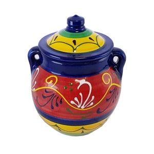 May include: A hand-painted ceramic jar with a lid. The jar is mainly red with blue, yellow, and green accents. It features decorative floral patterns in white and yellow. The jar has two handles and a matching lid.