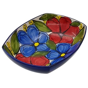 May include: A rectangular ceramic serving bowl with a blue rim and a white background. The bowl is decorated with hand-painted red and blue flowers with yellow centres and green leaves.