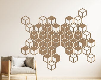 May include: A white wall with a geometric pattern of brown cork squares arranged in a honeycomb design. A light gray armchair with a white cushion sits in front of the wall. A small potted plant is on the left side of the image.