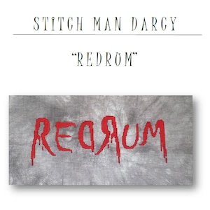 Puede incluir: Patrón de punto de cruz de la palabra "REDRUM" en rojo sobre un fondo gris. El título "Stitch Man Darcy" y "REDROM" están escritos sobre el patrón.