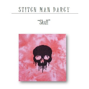 Op de afbeelding: Een zwart-wit kruissteekontwerp van een schedel op een roze en witte tie-dye achtergrond. Het ontwerp is getiteld "Skull".