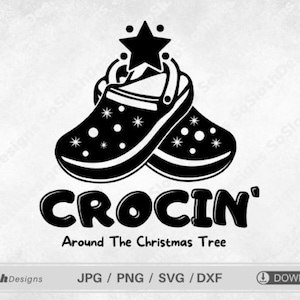 Puede incluir: Ilustración en blanco y negro de dos zuecos con una estrella en la parte superior. El texto "CROCIN' Around The Christmas Tree" está debajo de los zapatos.