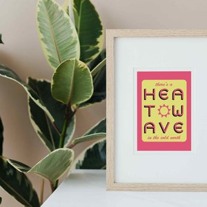 'Heatwave in the Cold North' print. Pink/yellow with the words 'there's a' and 'in the cold north' at the top/bottom, & 'HEATWAVE' in pink in the middle with a sunshine. On white background. Colour Combo 4