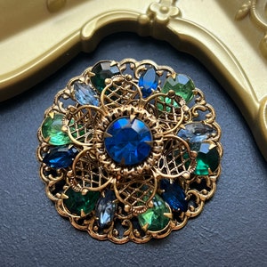 Vintage 3D ronde blauwgroene strass goudkleurige open filigraan brochespeld, Tsjechische/Duitsland-stijl