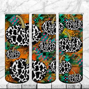 Puede incluir: Tres vasos de acero inoxidable con un diseño de calabaza de estampado de vaca en blanco y negro. El fondo es un patrón geométrico colorido con colores naranja, azul verdoso, rosa y marrón.