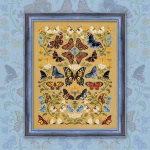 Puede incluir: Un bordado de punto de cruz enmarcado que presenta una variedad de mariposas coloridas dispuestas en un patrón simétrico sobre un fondo beige. Las mariposas están rodeadas de follaje verde y pequeñas flores blancas.