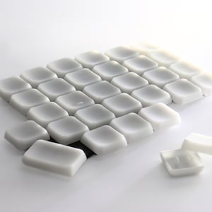 May include: A white keyboard with rounded keys. The keys are arranged in a grid pattern and are slightly raised. The keyboard is made of a soft, flexible material.