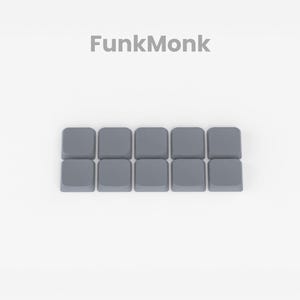 May include: Ten gray keycaps for a mechanical keyboard. The keycaps are arranged in a row.