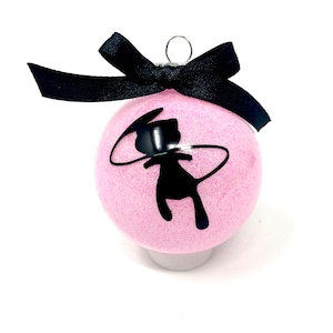 May include: Pink glitter Christmas ornament with a black cat silhouette design. The ornament has a black ribbon bow and a silver metal loop for hanging. A festive holiday decoration.