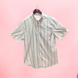 May include: A light blue and white striped short-sleeved button-down shirt.