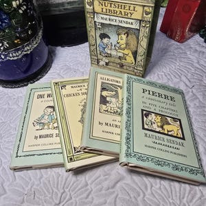 May include: A Maurice Sendak Nutshell Library boxed set containing four small books titled One Was Johnny, Chicken Soup with Rice, Alligators All Around, and Pierre. The books feature cream and light green covers with black ink illustrations.