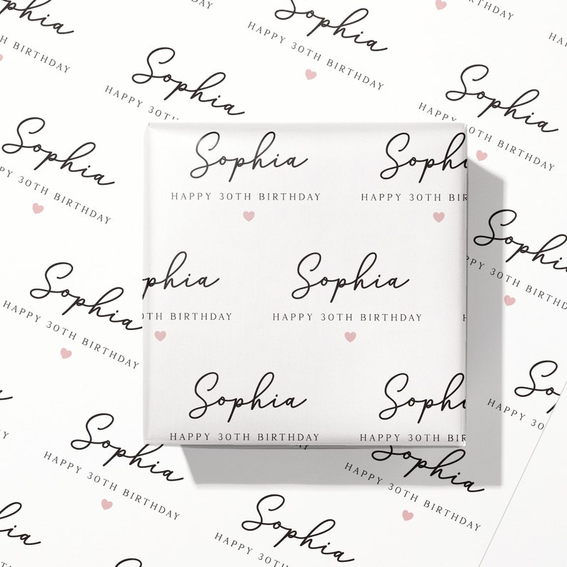 May include: White wrapping paper featuring the name "Sophia", the text "Happy 30th Birthday", and pink heart motifs. The design is repeated across the paper, suitable for a 30th birthday gift.