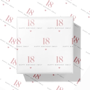 May include: White wrapping paper with a repeating pattern of the number "18", the words "Happy Birthday Emily", and small pink hearts. The design is in a soft pink color. The paper is wrapped around a gift.